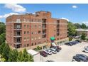 Exterior view of the brick condominium building featuring private balconies and convenient parking at 326 Roswell Se St # 406, Marietta, GA 30060