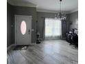 Inviting living room featuring tiled floors, a decorative chandelier and a view of the front yard at 3560 Elinburg Dr, Buford, GA 30519