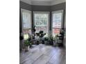 Light-filled sunroom with tile floors, multiple windows, and an array of lush plants and natural light at 3560 Elinburg Dr, Buford, GA 30519