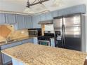 Modern kitchen with stainless steel appliances, light blue cabinets, and granite countertops on the island at 795 Abbotts Mill Ct # 73, Johns Creek, GA 30097