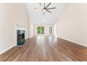 Bright living room features wood floors, fireplace, high ceiling with fan and a beautiful view of the backyard at 4210 Platinum Ct, Hoschton, GA 30548