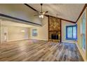 Bright living room featuring a stone fireplace, vaulted ceiling, ceiling fan, and wood-look flooring at 2685 Peachtree Walk Walk, Duluth, GA 30096