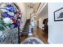 Elegant foyer with hardwood floors, staircase, chandelier and an ornate flower arrangement at 525 Avala Ct, Johns Creek, GA 30022