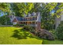 Landscaped lawn surrounds this two-story home with a covered porch at 441 Belgrave Ln, Tucker, GA 30084