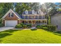 Beautiful brick home with shutters and a manicured front lawn with landscaping at 441 Belgrave Ln, Tucker, GA 30084