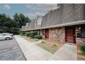 Attractive brick townhome exterior featuring a sidewalk, parking area and mature trees at 3101 Reeves Se St, Smyrna, GA 30080
