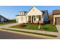 An inviting one-story home features a well-maintained lawn, a classic covered porch and a side entry two-car garage at 1693 Juniper Berry Way, Loganville, GA 30052