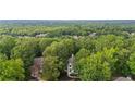 Aerial view of a beautiful home nestled among lush greenery with mature trees and a well-manicured lawn at 1755 Noblin Summit Dr, Duluth, GA 30097