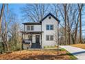 Charming two-story home with white siding, black trim, gabled roof, and a concrete driveway at 2860 3Rd Sw Ave, Atlanta, GA 30315