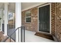 Welcoming front porch featuring brick accents, white columns, and a classic black front door at 1648 Danbury Parc Ne Pl, Brookhaven, GA 30319
