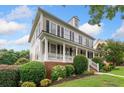 Beautiful home with a covered front porch, lush landscaping, and classic architectural details at 1235 Renaissance Se Ct, Mableton, GA 30126