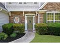 Inviting front entrance with stone detailing and a decorative wreath on the green door at 3559 Reservoir Pass, Acworth, GA 30101