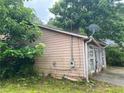 View of the side of a house with siding and overgrown greenery at 5035 Chadwick Ct, Decatur, GA 30035