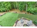 Backyard featuring green turf, putting green, and patio with chairs perfect for outdoor living at 5930 Shannon Drive Dr, Cumming, GA 30040