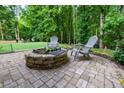 Seating area with a stone fire pit nestled in a backyard featuring turfed lawn, perfect for relaxing at 5930 Shannon Drive Dr, Cumming, GA 30040