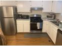 Galley kitchen featuring stainless steel appliances, white cabinetry, and modern countertop, providing a functional cooking space at 8955 Stonebridge Blvd, Douglasville, GA 30134