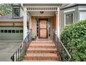 Inviting front porch with brick steps, wrought iron railings and views of the attached two-car garage at 1685 Frazier Park Dr, Decatur, GA 30033