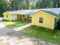 Exterior view of the charming yellow home with metal roof and covered porch at 5357 Highway 81, Loganville, GA 30052