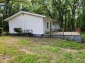 Rear exterior view of home, featuring a small patio and a yard surrounded by lush greenery at 3705 Orchard Dr, Atlanta, GA 30349