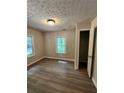 Bright bedroom with wood-look flooring, neutral walls, and a window overlooking a lush, green landscape at 3705 Orchard Dr, Atlanta, GA 30349