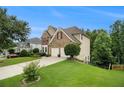 Well-maintained home with lush green lawn and mature trees, showcasing its curb appeal at 5925 Crescent Landing Dr, Cumming, GA 30028