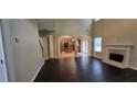 Open-concept living space connects to kitchen and dining area with fireplace and wood floors at 571 Cold Water Ln, Mcdonough, GA 30252