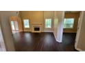Bright living room boasts high ceilings, fireplace, wood floors, and large windows at 571 Cold Water Ln, Mcdonough, GA 30252
