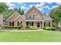 Charming red brick two-story home featuring a large front yard with landscaped bushes and a covered front porch at 1640 Mount Mckinley Dr, Grayson, GA 30017