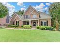Charming brick home with manicured lawn, lush landscaping and inviting front porch at 1640 Mount Mckinley Dr, Grayson, GA 30017
