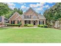 Charming brick home with manicured lawn, lush landscaping and inviting front porch at 1640 Mount Mckinley Dr, Grayson, GA 30017