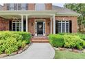 Inviting front porch with black door, brick and beautiful landscaping at 1640 Mount Mckinley Dr, Grayson, GA 30017