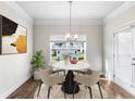 Charming breakfast nook features a marble table set for four, complemented by an elegant chandelier and natural light at 1494 Weeping Tree Cir, Auburn, GA 30548