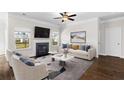 Bright living room with a fireplace, large windows, hardwood floors, and comfortable seating for relaxing and entertaining guests at 1494 Weeping Tree Cir, Auburn, GA 30548
