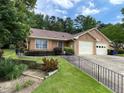 Charming single-story home with a two-car garage, landscaped front yard, and nice lawn at 7123 Woodridge Ln, Union City, GA 30291