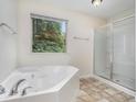 Bright bathroom with soaking tub, glass shower, and tiled floor at 2035 Stonebrook Dr, Austell, GA 30106