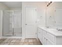 White bathroom features a glass enclosed shower, tile floor and double sink vanity at 2035 Stonebrook Dr, Austell, GA 30106