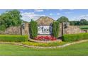 Stone entrance to Ascot community with manicured landscaping and signature signage at 4935 Stablegate Ct, Cumming, GA 30028