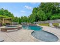 Inviting backyard pool and spa area with lush landscaping, perfect for relaxation and entertaining at 108 Fountain Oak, Villa Rica, GA 30180