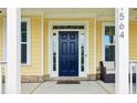 Elegant blue front door framed by sidelights and a covered porch at 1564 Brunswick St, Lithia Springs, GA 30122