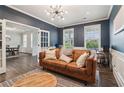 Stylish living room with dark blue walls, wainscoting, modern light fixture, and hardwood floors at 1564 Brunswick St, Lithia Springs, GA 30122