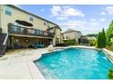 Backyard pool featuring a covered patio, outdoor seating, and meticulously maintained landscaping at 4425 Martel Dr, Cumming, GA 30040