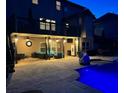Backyard pool with covered patio and outdoor seating illuminated at dusk at 4425 Martel Dr, Cumming, GA 30040