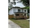 Beautiful two-story home with a wooden porch, fenced yard, and lush green lawn at 1962 Compton Se Dr, Atlanta, GA 30315