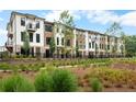 Beautiful townhome exterior with a landscaped front yard, black fencing and a private balcony at 334 Olmstead Way # 37, Alpharetta, GA 30022
