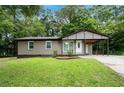 Inviting single story home with a cozy carport and lush green lawn at 6658 Collins Ct, Riverdale, GA 30274