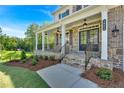 Inviting front porch with stone base, decorative columns, and wrought iron railings at 1065 Low Water Crossing Nw, Acworth, GA 30101