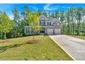 Well-maintained lawn and landscaping highlight this attractive two-story house with a long driveway at 1065 Low Water Crossing Nw, Acworth, GA 30101