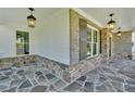 Spacious porch featuring stone flooring, overhead lighting, and stylish stone and shingle details at 1065 Low Water Crossing Nw, Acworth, GA 30101