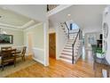 Inviting foyer with hardwood floors, staircase with dark trim, and views into the dining and living areas at 4075 Hickory Fairway Dr, Woodstock, GA 30188