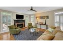Cozy living room with fireplace, shuttered windows, ceiling fan and comfortable seating arrangement at 4075 Hickory Fairway Dr, Woodstock, GA 30188